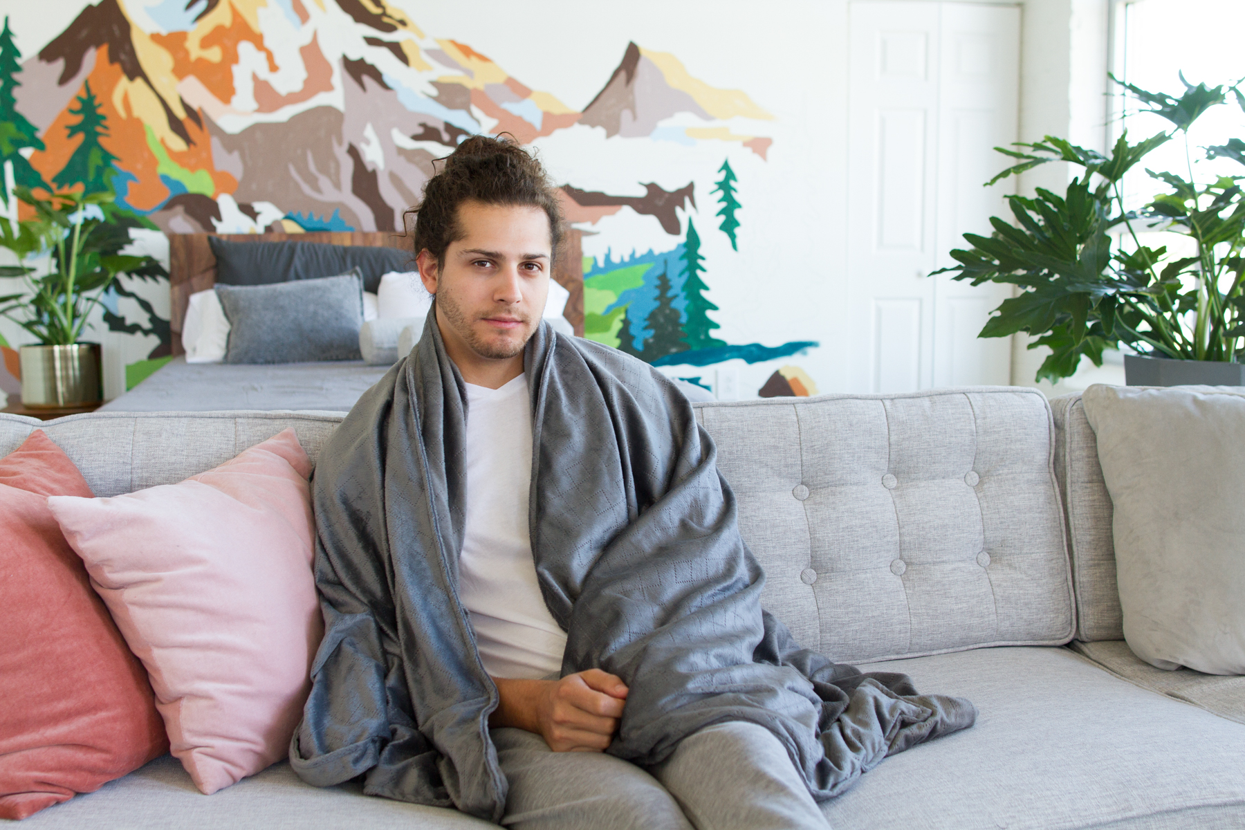 man wrapped in blanket on sofa