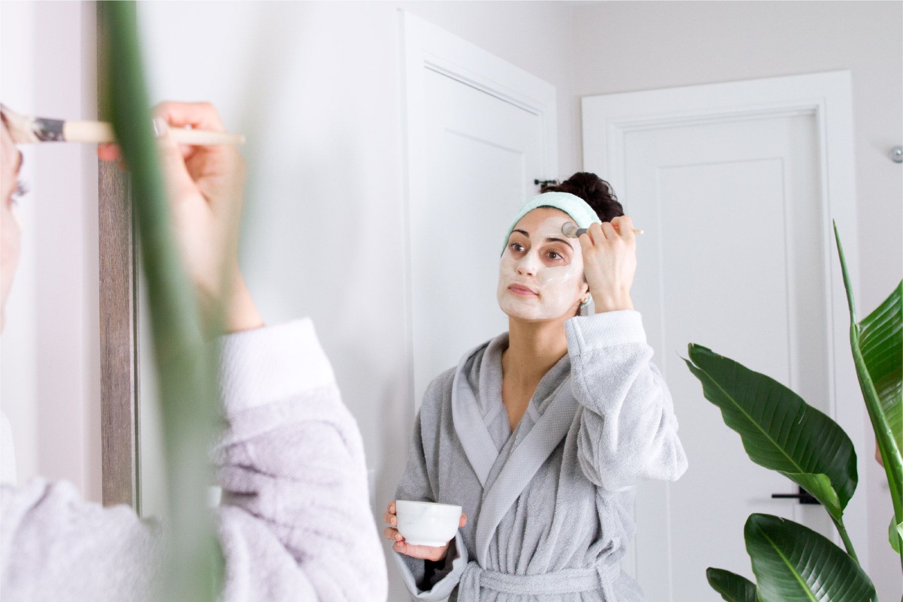 woman in robe applying a DIY face mask
